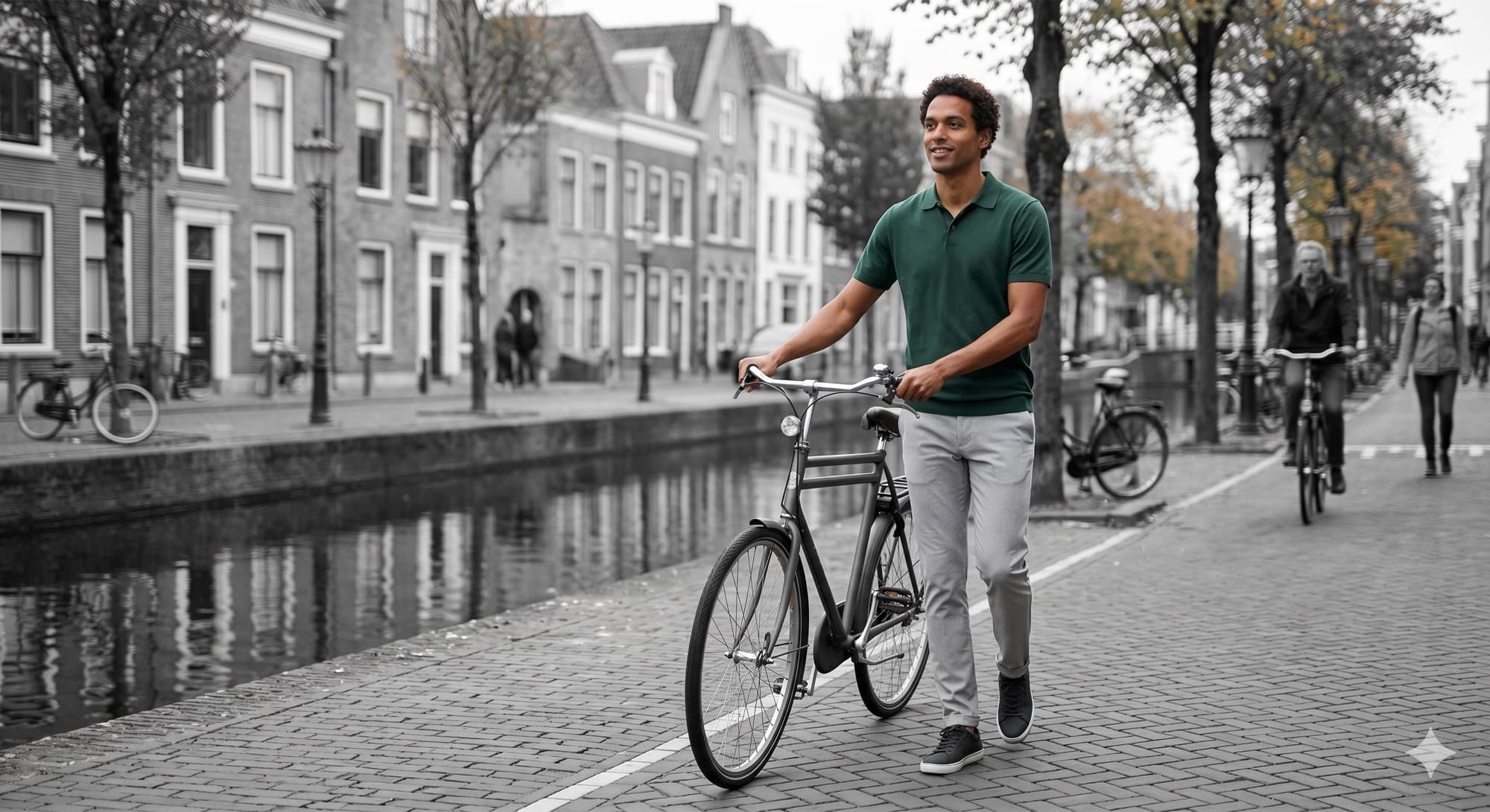 A man with a bicycle along a Bruges canal